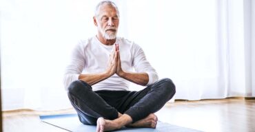 senhor sentado no chão praticando a meditação para idosos