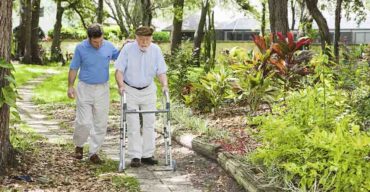 dois homens caminhando com muletas após terem AVC em idosos