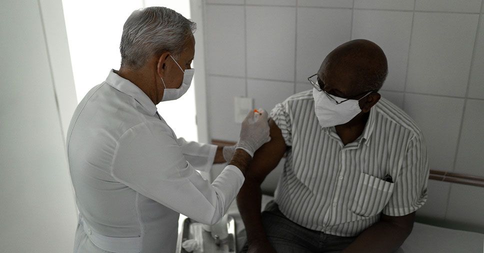 Médico aplicando vacina em um homem