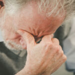 Homem com as mãos no rosto pensando na depressão em idosos
