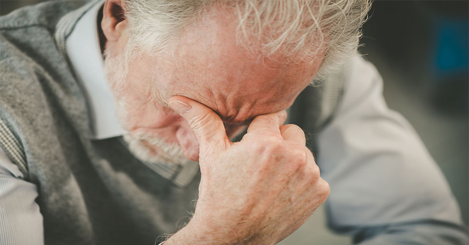 Homem com as mãos no rosto pensando na depressão em idosos