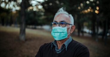 Homem idoso usando máscara contra covid em um parque