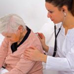 Médica aferiando a respiração. Veja mais sobre pneumonia em idosos!