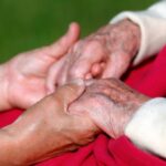 Close de mãos entrelaçadas em sinal de apoio ilustra o cansaço de cuidar dos pais.